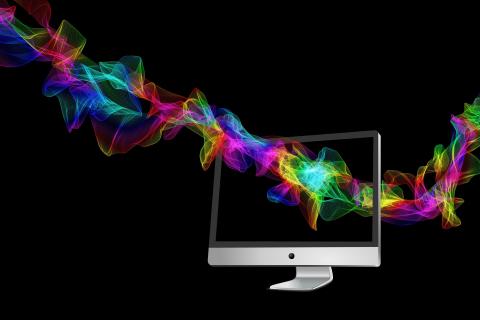 Multi-colored particle waves flowing through computer screen