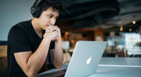 Guy staring at his laptop screen. Seems frazzled.